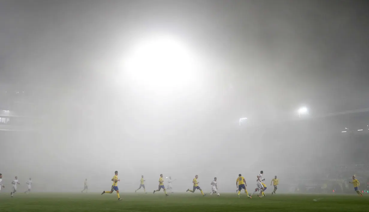 Pemain FC Fastav Zlin dan F.C. Copenhagen saat bertanding dengan suasana kabut tebal pada Grup F Liga Europa di Stadion Andruv, Ceko (19/10). Kabut tebal mendadak menutup stadion yang menyebabkan berkurangnya jarak pandang. (AP Photo/Petr David Josek)