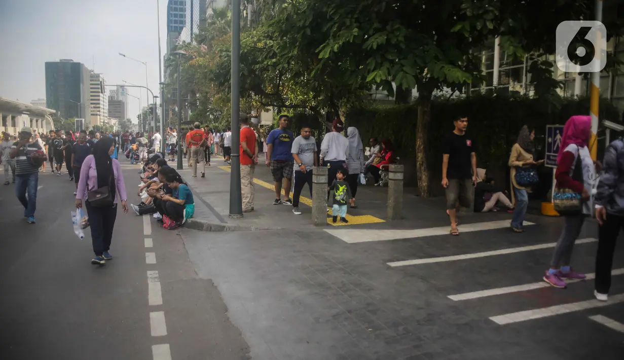 Petugas Satpol PP berjaga saat warga berolahraga pada car free day (CFD) di kawasan Bundaran HI, Jakarta, Minggu (17/11/2019). Usai ditertibkan, tak terlihat satu pun PKL yang berjualan di lokasi tersebut. (Liputan6.com/Faizal Fanani)