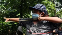 Anak-anak yang tergabung dalam Ketapel Anak Ciliwung (Kancil) bermain ketapel di kawasan Ciliwung Muara Baru, Jakarta, Selasa (9/11/2021). Selain melestarikan permainan tradisional, bermain ketapel dapat melatih kesabaran, konsentrasi dan motorik otak kanan bagi anak. (Liputan6.com/Herman Zakharia)