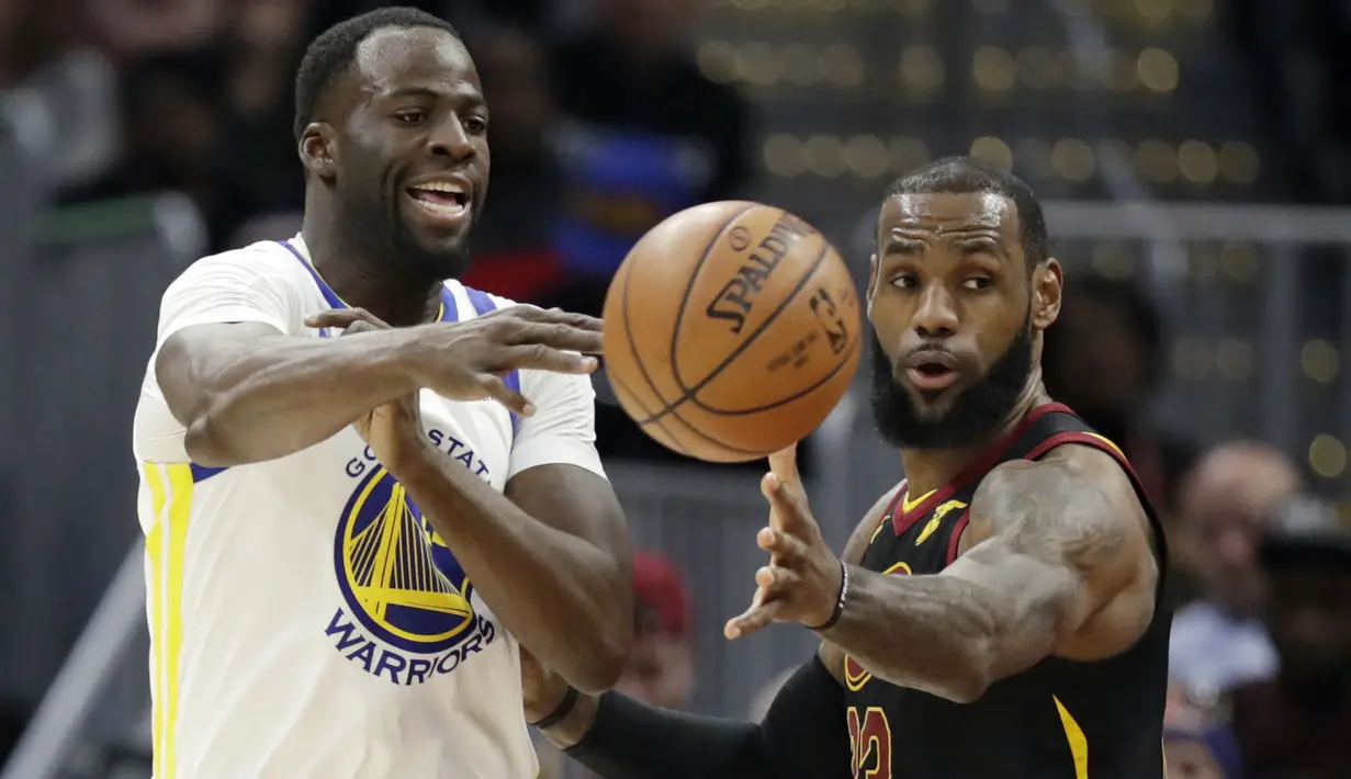 Pemain Warriors, Draymond Green melepaskan umpan melewati pemain Cavaliers, LeBron James (kanan) pada lanjutan NBA basketball game di Quicken Loans Arena, Cleveland, (15/1/2018). Warriors menang 118-108. (AP/Tony Dejak)
