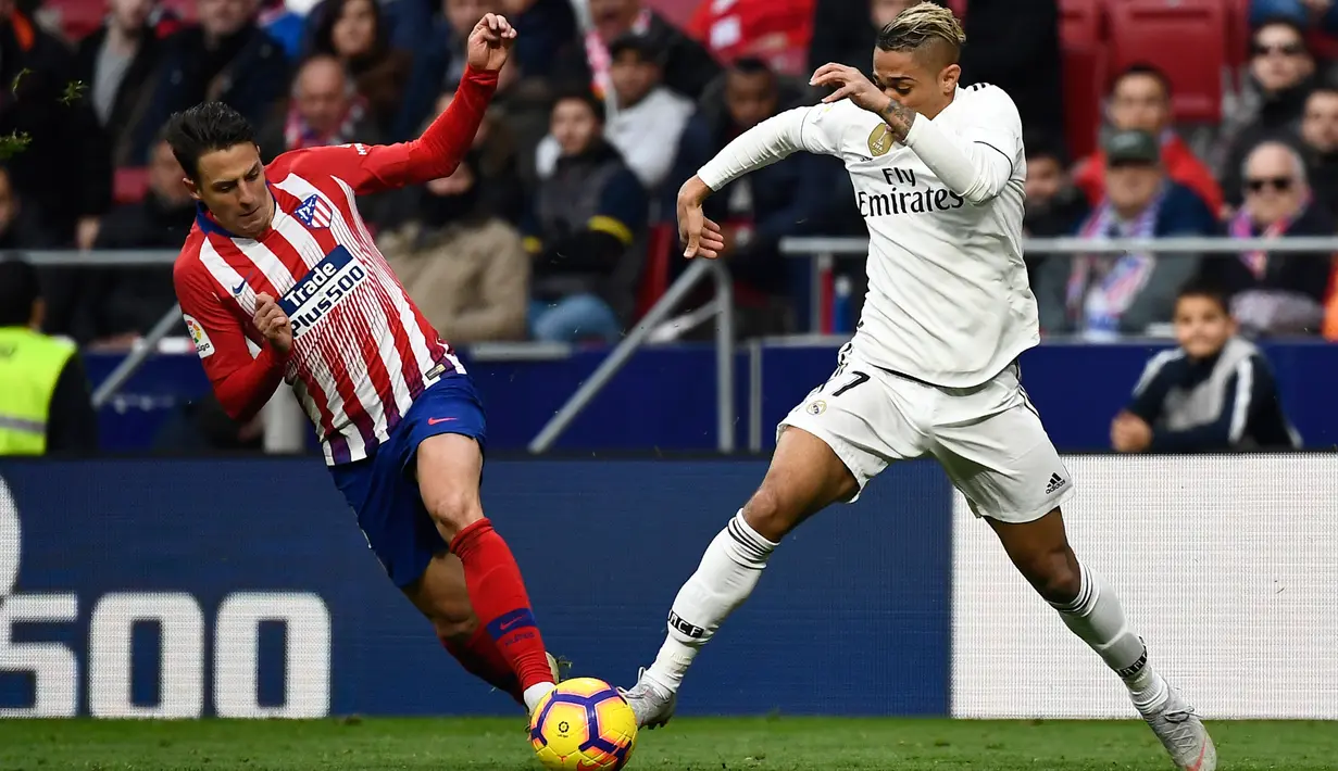 Bek Atletico Madrid, Santiago Arias berusaha merebut bola yang dibawa striker Real Madrid, Mariano selama pertandingan lanjutan La Liga Spanyol di stadion Wanda Metropolitano (9/2). Real Madrid menang 3-1 atas Atletico. (AFP Photo/Pierre-Philippe Marcou)