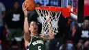 Pebasket Milwaukee Bucks, D.J. Wilson, memasukkan bola saat melawan Washington Wizards pada laga NBA, Selasa (11/8/2020). Bucks mengalahkan Wizards dengan skor 126-113. (AP Photo/Ashley Landis, Pool)