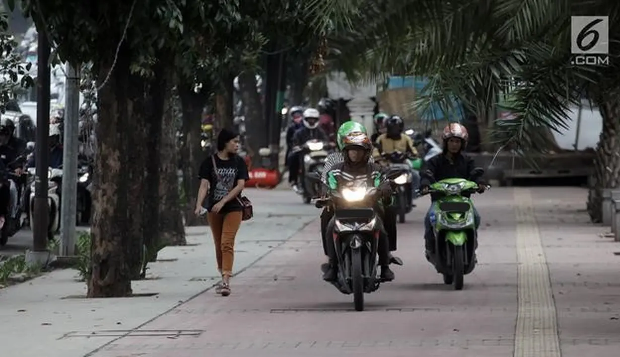 Gerombolan pemotor berjalan di atas trotoar sehingga pejalan kaki harus mengalah ke pinggir. (Source: liputan6.com)