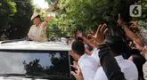Presiden Republik Indonesia Prabowo Subianto menyapa warga sekaligus membagikan kaos seusai kunjungan dari Sekolah Dasar Negeri (SDN) Jati 03, Jakarta, Rabu (7/5/2025). (Liputan6.com/Herman Zakharia)
