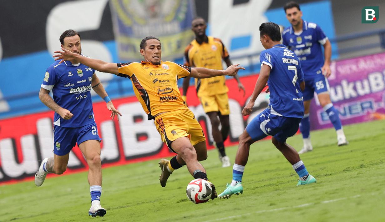 Pemain Persija Jakarta, Hanif Sjahbandi (tengah) berusaha melewati penjagaan pemain Persib Bandung dalam laga lanjutan BRI Super League 2025/2026 di Stadion Gelora Bandung Lautan Api, Bandung, Minggu (11/01/2026). (Bola.com/Abdul Aziz)