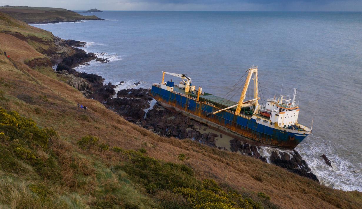 Kapal kargo sepanjang 77 meter, MV Alta,  terjebak di atas batu di dekat Ballycotton, Cork, Irlandia, Selasa (18/2/2020). "Kapal hantu" yang berlayar tanpa awak selama lebih dari satu tahun hanyut dan terbawa ke pantai selatan Irlandia menyusul sapuan Badai Dennis. (Cathal Noonan/AFP)