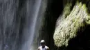 Seorang peziarah mandi di bawah air terjun di Saut d' Eau, Haiti, (16/7). Mereka merupakan penganut aliran Voodoo menggelar ritual mandi suci di air terjun Saut D'Eau. (REUTERS/Andres Martinez Casares)