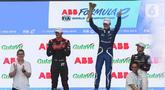 Pembalap tim Maserati MSG Racing Maximilian Gunther (tengah) mengangkat piala seusai balapan Formula E 2023 Jakarta seri ke-11 di Jakarta International E-Prix Circuit (JIEC), Jakarta, Minggu (4/6/2023). (Liputan6.com/Herman Zakharia)