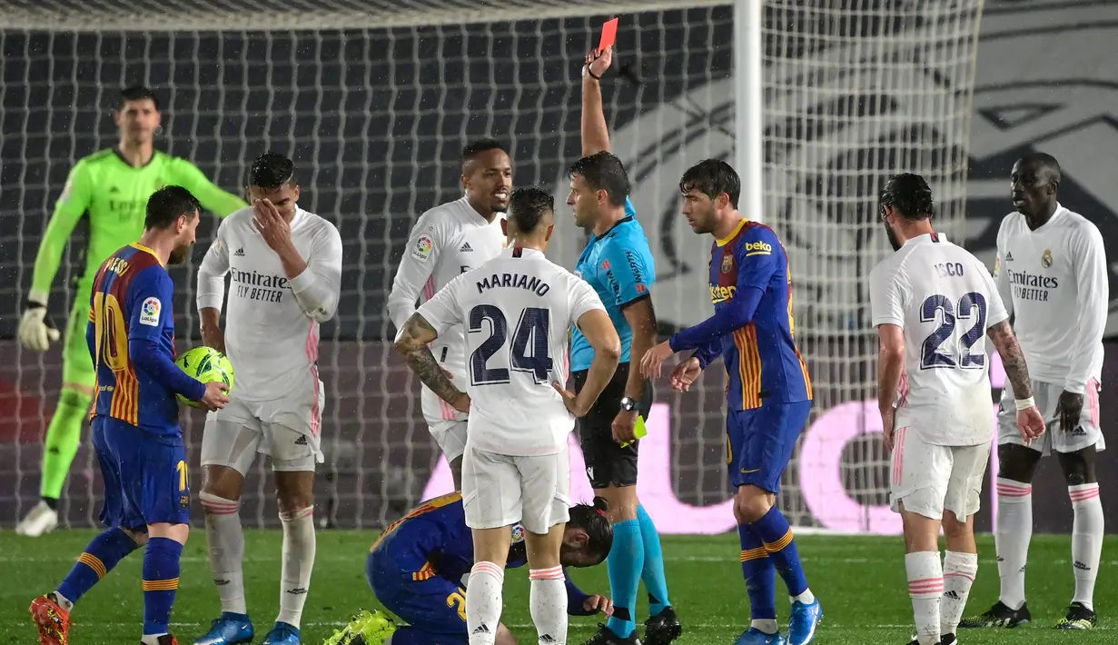 Wasit Jesus Gil Manzano memberikan kartu merah kepada gelandang Real Madrid, Casemiro (kedua dari kiri) saat melawan Barcelona dalam laga lanjutan Liga Spanyol 2020/2021 pekan ke-30 di Alfredo di Stefano Stadium, Madrid, Sabtu (10/4/2021). Real Madrid menang 2-1 atas Barcelona. (AFP/Javier Soriano)