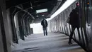 Seorang pria berjalan di sepanjang platform yang tertutup salju di stasiun kereta saat badai saljudi Brooklyn, New York, Senin, (1/2/2021). Badai salju menyebabkan timbunan salju setinggi satu kaki di sepanjang wilayah pesisir timur Amerika Serikat, termasuk Kota New York. (AP Photo/Wong Maye-E)