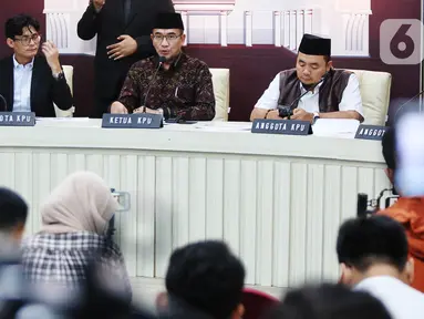 Ketua Komisi Pemilihan Umum (KPU) Republik Indonesia, Hasyim Asyari (tengah) didampingi anggota KPU August Mellaz (kiri) dan Mochammad Afifuddin (kanan) memberikan keterangan di kantor KPU, Jakarta, Senin (12/2/2024). (Liputan6.com/Angga Yuniar)