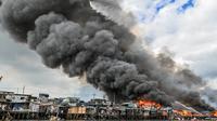 Helikopter Angkatan Udara Filipina menjatuhkan air di atas pemukiman kumuh yang terbakar di Tondo, Manila, Filipina. (AFP)