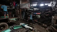 Pekerja membawa bagian Koperasi Angkutan Jakarta (Kopaja) yang telah dibongkar untuk diremajakan di kawasan Meruya, Jakarta Barat, Rabu (27/1/2021). Kopaja yang tak lagi digunakan tersebut dihancurkan untuk dijual secara kiloan ke penjual besi tua. (Liputan6.com/Johan Tallo)