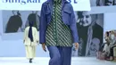 Syahnaz Sadiqah juga turut tampil sebagai model untuk Zaskia Sungkar x NASL. Ia mengenakan kerudung abu-abu yang dipadukan dengan crop outer berwarna navy yang memiliki kantong, serasi dengan celana panjangnya. Di bawah outer, ia mengenakan inner berupa kemeja bermotif hijau. [Dok/Fimela/Adrian Utama P].