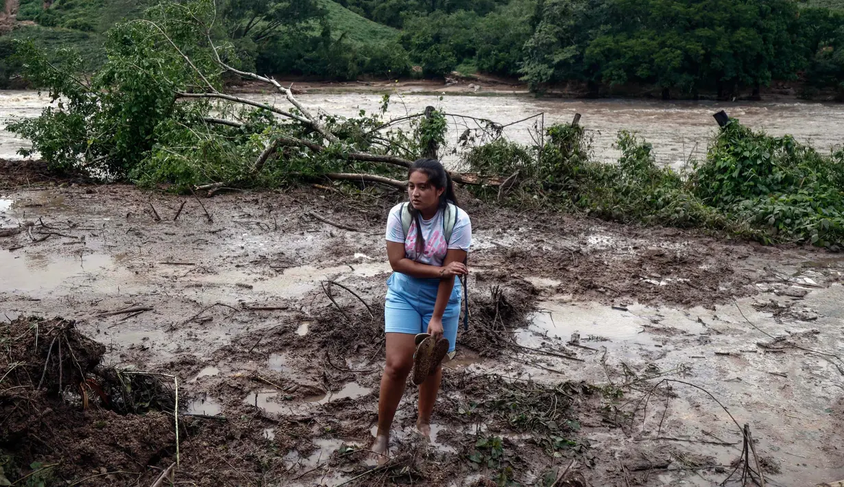 Seorang wanita berdiri di tengah lumpur dan puing-puing di komunitas Kilometro 42, dekat Acapulco, Negara Bagian Guerrero, Meksiko, setelah dilalui Badai Otis, pada 25 Oktober 2023. (RODRIGO OROPEZA/AFP)
