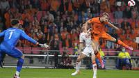 Bek timnas Belanda, Matthijs de Ligt menyundul bola saat kiper Montenegro Matija Sarkic mencoba menghalau pada laga lanjutan kualifikasi Piala Dunia 2022 di Stadion Phillips, Minggu (5/8/2021) dini hari WIB. Belanda sukses menghantam Montenegro dengan skor 4-0. (AP Photo/Peter Dejong)