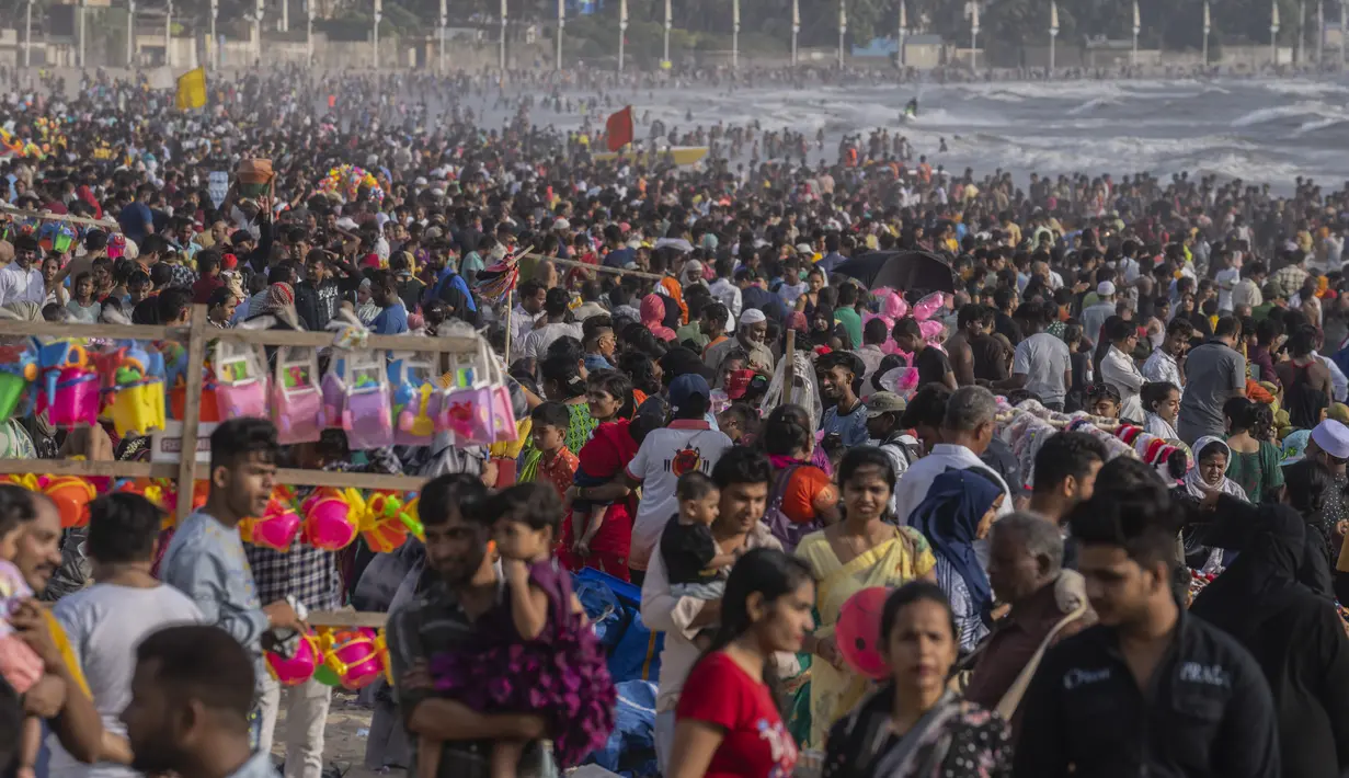 <p>Warga memadati pantai Juhu di Laut Arab pada hari yang panas dan lembab di kota Mumbai, India, 8 Mei 2022. Musim panas yang terik di India menambah risiko baru tahun ini. Suhu di India melebihi 40 derajat Celcius di banyak daerah. (AP Photo/Rafiq Maqbool)</p>