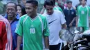 Ramdani Lestaluhu bersenda gurau dengan warga sekitar sebelum memasuki lapangan pertandinga. (Bola.com/Peksi Cahyo)