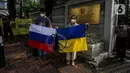 Masyarakat dari "Solidaritas untuk Rakyat Ukraina" membentangkan bendera Rusia dan Ukrainan di depan Kedubes Rusia, Jakarta, Jumat (4/3/2022). Mereka menyerukan kepada Dubes Rusia di Indonesia untuk bersuara menghentikan serangan yang dilakukan Rusia terhadap Ukraina. (Liputan6.com/Johan Tallo)