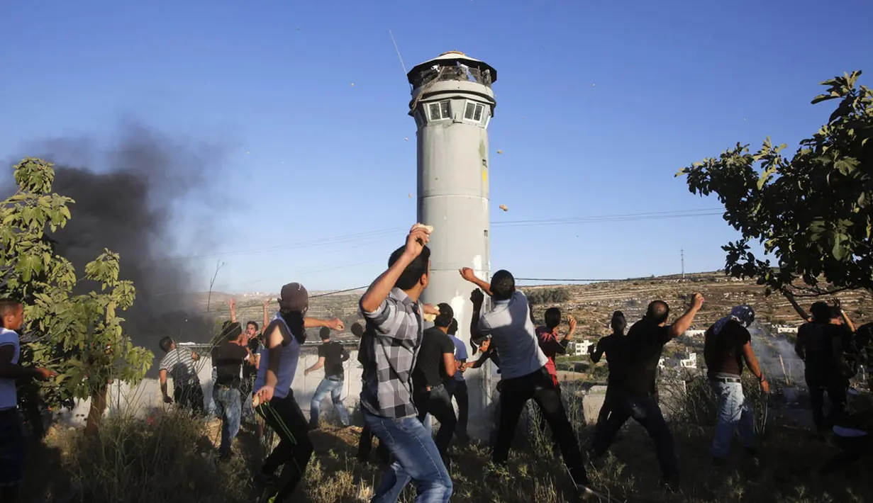 Warga Palestina melempari batu ke arah tentara Israel di Beit Ommar, utara kota Hebron, (25/7/2014). (REUTERS/Mussa Qawasma)