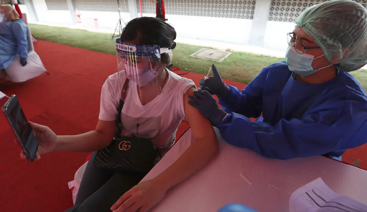 Seorang wanita menerima suntikan vaksin Sinovac saat vaksinasi massal virus corona COVID-19 untuk umum di Stadion Patriot Candrabhaga, Bekasi, Jawa Barat, Senin (14/6/2021). Peminat vaksinasi COVID-19 di Stadion Patriot Candrabagha sangat tinggi. (AP Photo/Achmad Ibrahim)