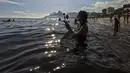 Pemuja dewi laut Yemanja menempatkan persembahan bunga di perairan pantai Arpoador selama perayaan tahunan di Rio de Janeiro, Brasil, Kamis, 2 Februari 2023. Dalam kepercayaan Afro-Brasil, Yemanja diyakini sebagai representasi dewi laut yang cantik jelita. (AP Photo/Bruna Prado)