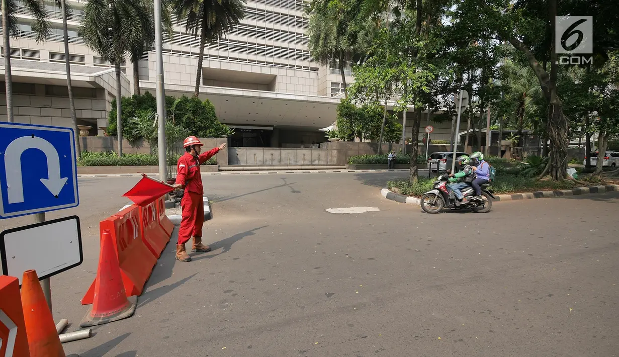 Petugas mengalihkan pengendara sepeda motor yang akan melintasi proyek pembangunan jalur kereta Light Rail Transit (LRT) di Jalan Setiabudi Tengah, Jakarta, Senin (17/6/2019). Jalan Setiabudi Tengah ditutup mulai 17 Juni 2019 hingga 20 Februari 2020. (Liputan6.com/Herman Zakharia)