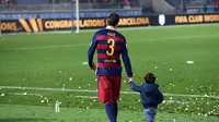 Bek Barcelona, Gerard Pique, turut mengajak putranya merayakan keberhasilan membawa Barca menjadi tim terbaik di dunia. (AFP/Toshifumi Kitamura)