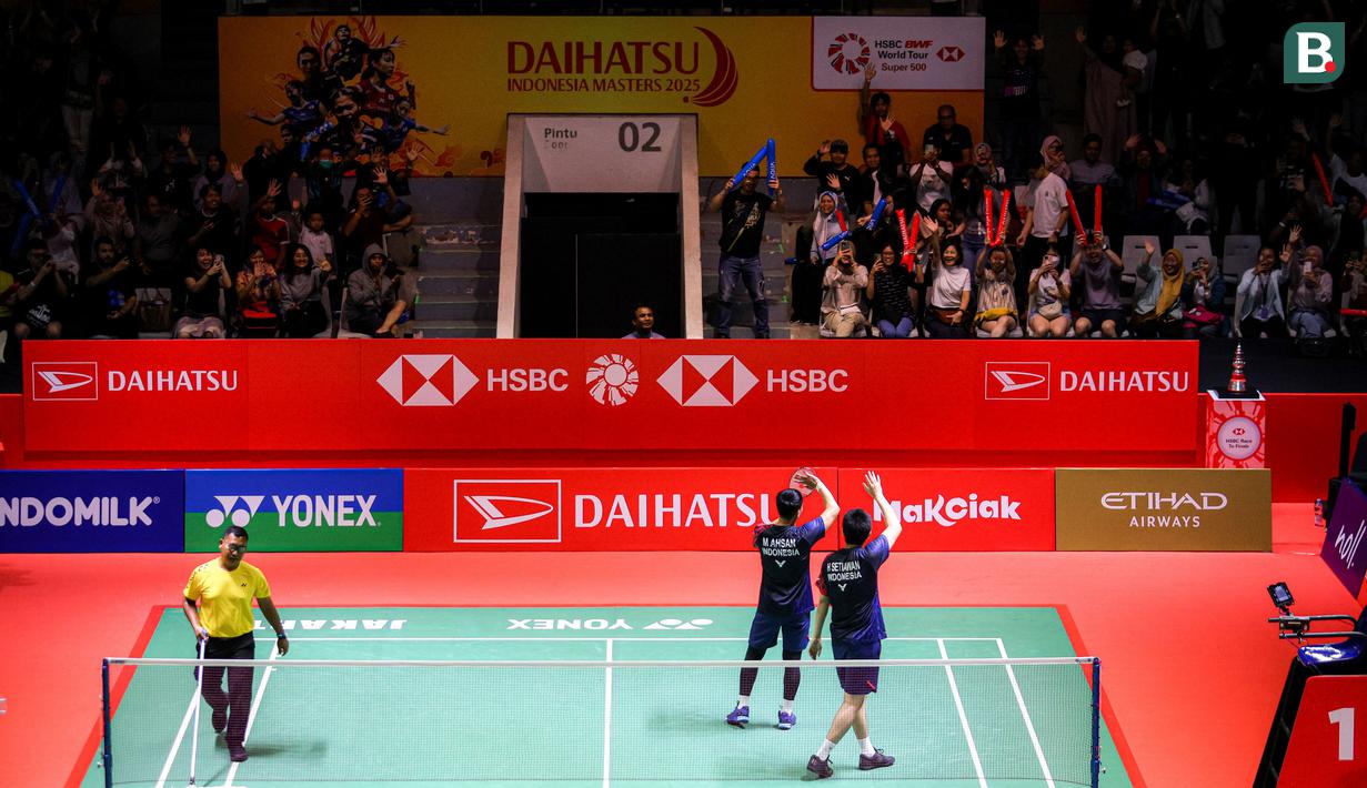 Ganda putra Indonesia, Hendra Setiawan/Mohammad Ahsan, menyapa fans setelah berhasil menaklukkan wakil Taiwan, Chiang Chien-Wei/Wu Hsuan-Yi pada babak 32 besar Indonesia Masters 2025 di Istora Senayan, Jakarta, Selasa (21/1/2025) sore WIB. (Bola.com/Bagas lazuardi)