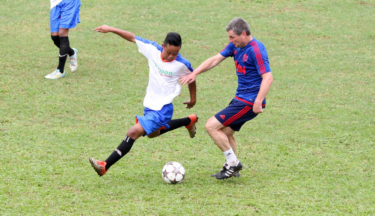 Legenda Manchester United, Denis Irwin (kanan), saat berebut bola dengan pemain Dream team B pada acara United Way Coaching Clinic You C 1000 di Stadion Soemantri Brojonegoro, Jakarta, Sabtu (7/5/2016). (Bola.com/Nicklas Hanoatubun)