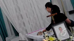 Salah satu kerabat melihat jenazah Rodrigo Gularte usai dimandikan di rumah duka Saint Carolus, Jakarta, Rabu (29/04/2015). Rencananya usai disemayamkan jenazah Rodrigo akan dipulangkan ke Brazil. (Liputan6.com/Andrian M Tunay)