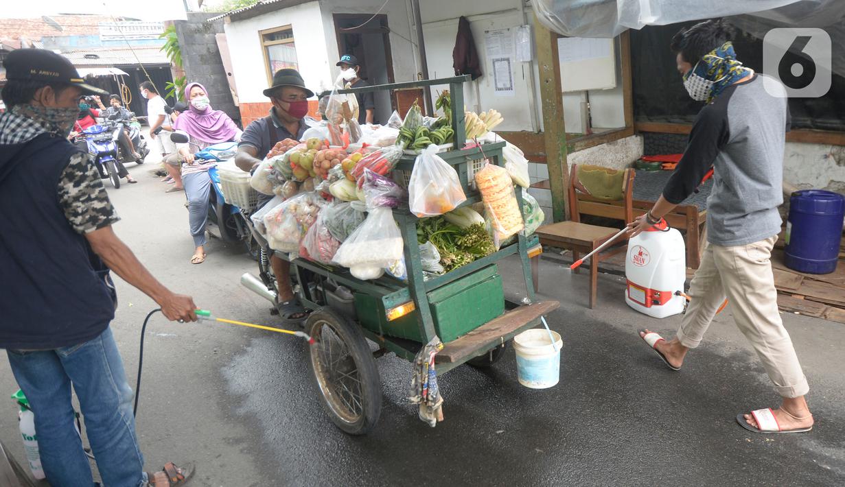 Sejumlah pemuda menyemprotkan cairan disinfektan kepada orang yang akan memasuki RW 10 di kawasan Tanah Kusir, Kelurahan Kebayoran Lama Selatan, Jakarta, Rabu (8/4/2020). Warga menerapkan akses satu pintu masuk pemukiman tersebut untuk mencegah penyebaran corona COVID-19. (merdeka.com/Dwi Narwoko)