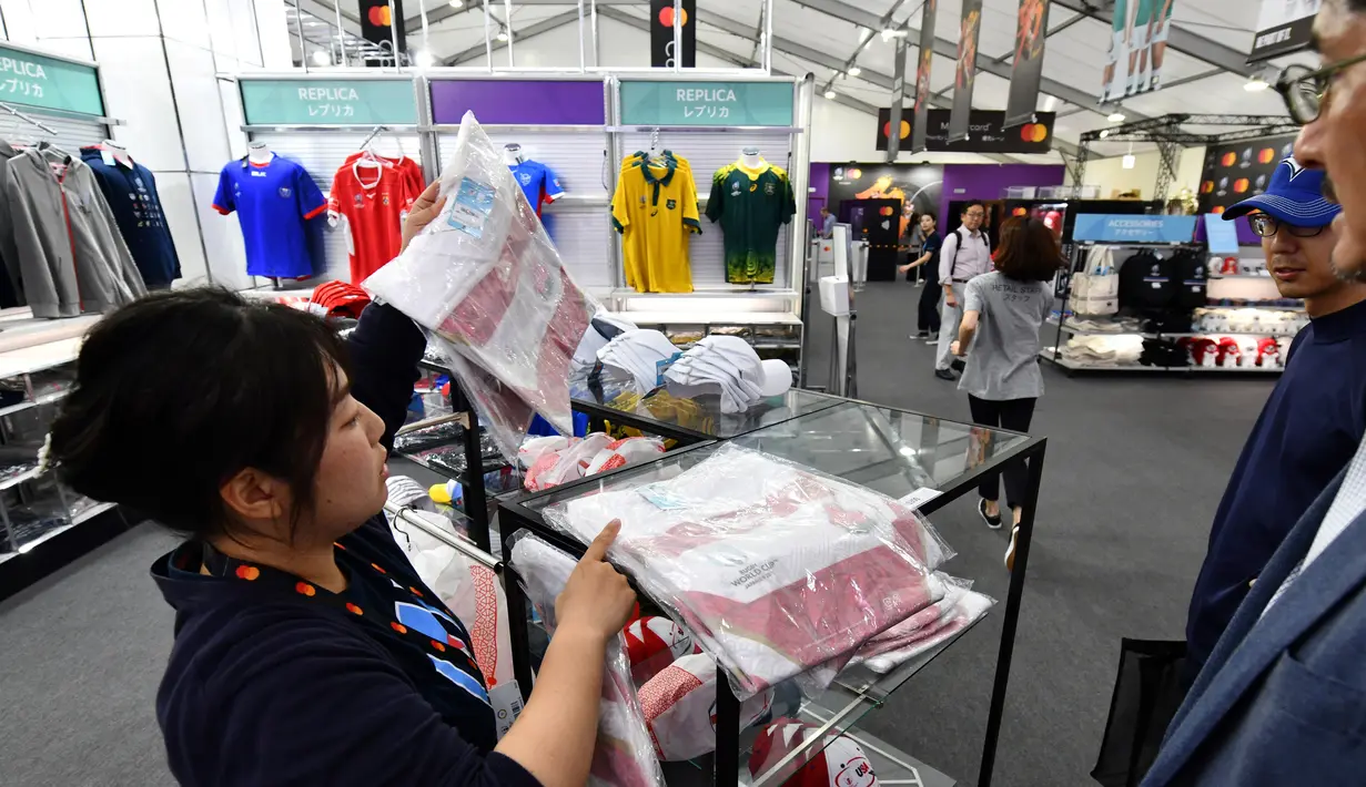 Pekerja melayani pengunjung di Rugby World Cup 2019 Megastore di distrik Shinjuku yang ramai di Tokyo (8/10/2019). Rugby World Cup diselenggarakan dari 20 September hingga 2 November 2019. (AFP Photo/Kazuhiro Nogi)