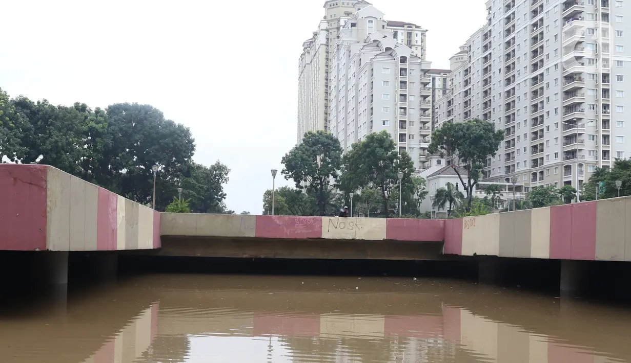 Warga melihat banjir yang mengenangi underpass Kemayoran, Jakarta, Minggu (2/2/2020). Banjir kembali merendam underpass Kemayoran, Jakarta Pusat. Akibatnya, akses jalur tersebut pun terputus alias tak bisa dilalui kendaraan. (Liputan6.com/Angga Yuniar)