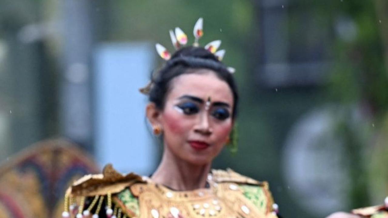 Dalam parade ini, peserta parade tampil dalam balutan baju tradisional hingga mengenakan topeng. Foto: AFP / SONNY TUMBELAKA<br>
