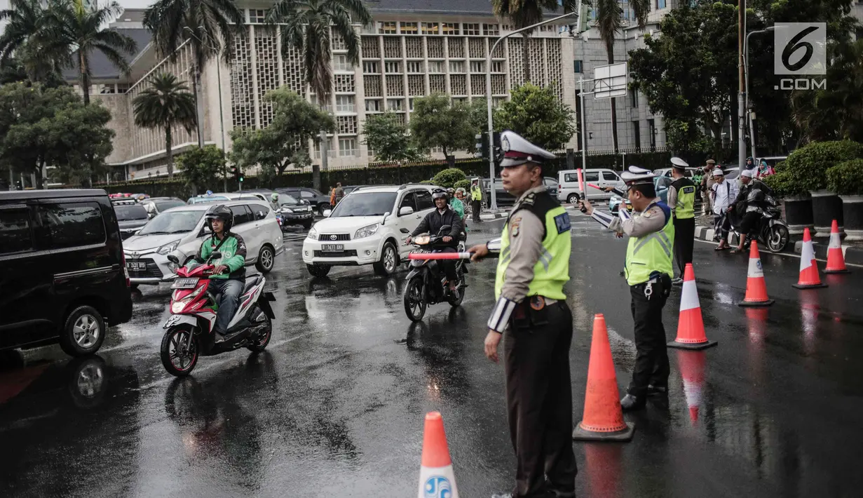 Polisi melakukan pengalihan arus lalu lintas terkait Malam Munajat 212 di Medan Merdeka Barat dan Utara, Jakarta, Kamis (21/2). Polisi menurunkan 12 ribu personel untuk mengamankan Malam Munajat 212 di Monas. (Liputan6.com/Faizal Fanani)