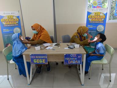Murid sekolah dasar diperiksa mulut dan giginya saat kegiatan Cek Kesehatan Gratis (CKG) di SD Prestasi Global, Depok, Jawa Barat, Senin (4/8/2025).
