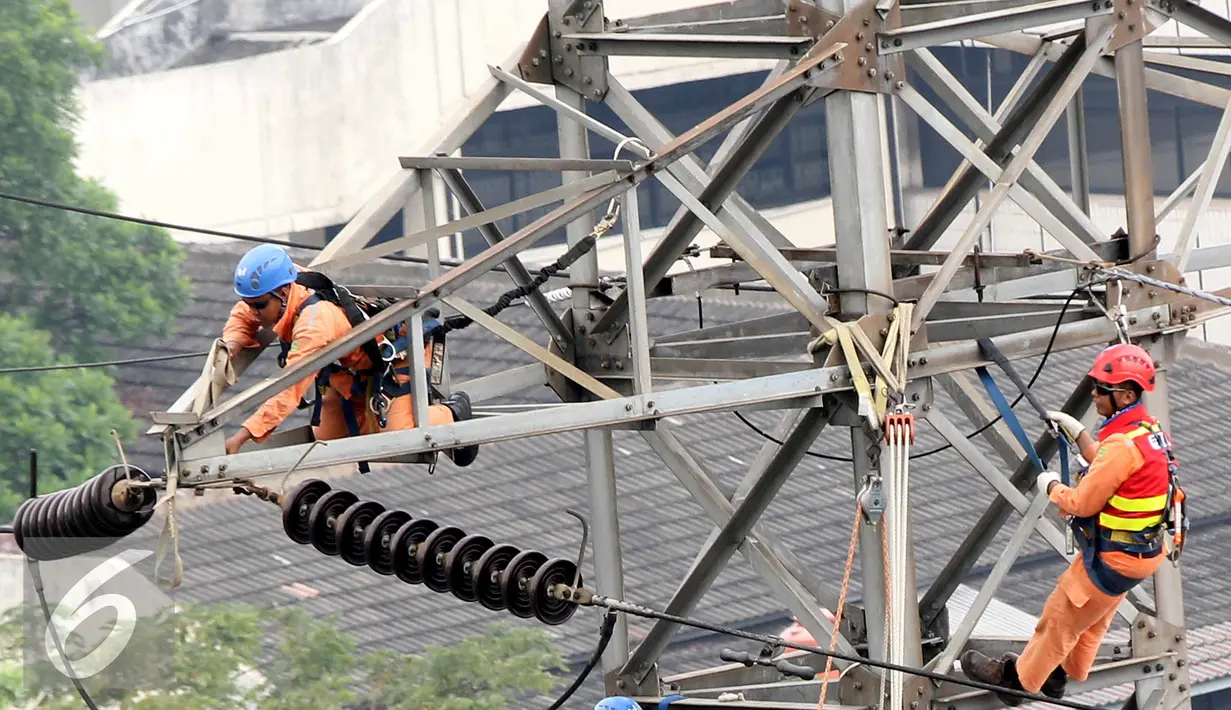 Petugas PLN memperbaiki Menara Sutet di Jalan Asia Afrika, Jakarta, Rabu (12/8/2015). Pekerjaan tersebut mengandung resiko besar karena jaringan listrik masih dipelihara tanpa dipadamkan. (Liputan6.com/Helmi Afandi)