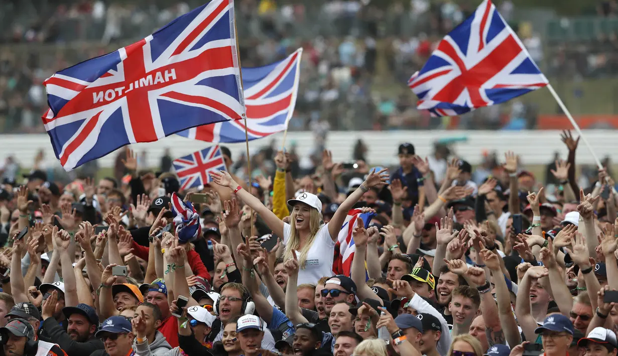 Fans merayakan keberhasilan pebalap Mercedes, Lewis Hamilton, menjuarai F1 GP Inggris di Sirkuit Silverstone, Minggu (16/7/2017). Pebalap 32 tahun asal Inggris itu melahap 51 lap dengan catatan waktu 1 jam 21 menit 27,430 detik. (AP/Frank Augstein)