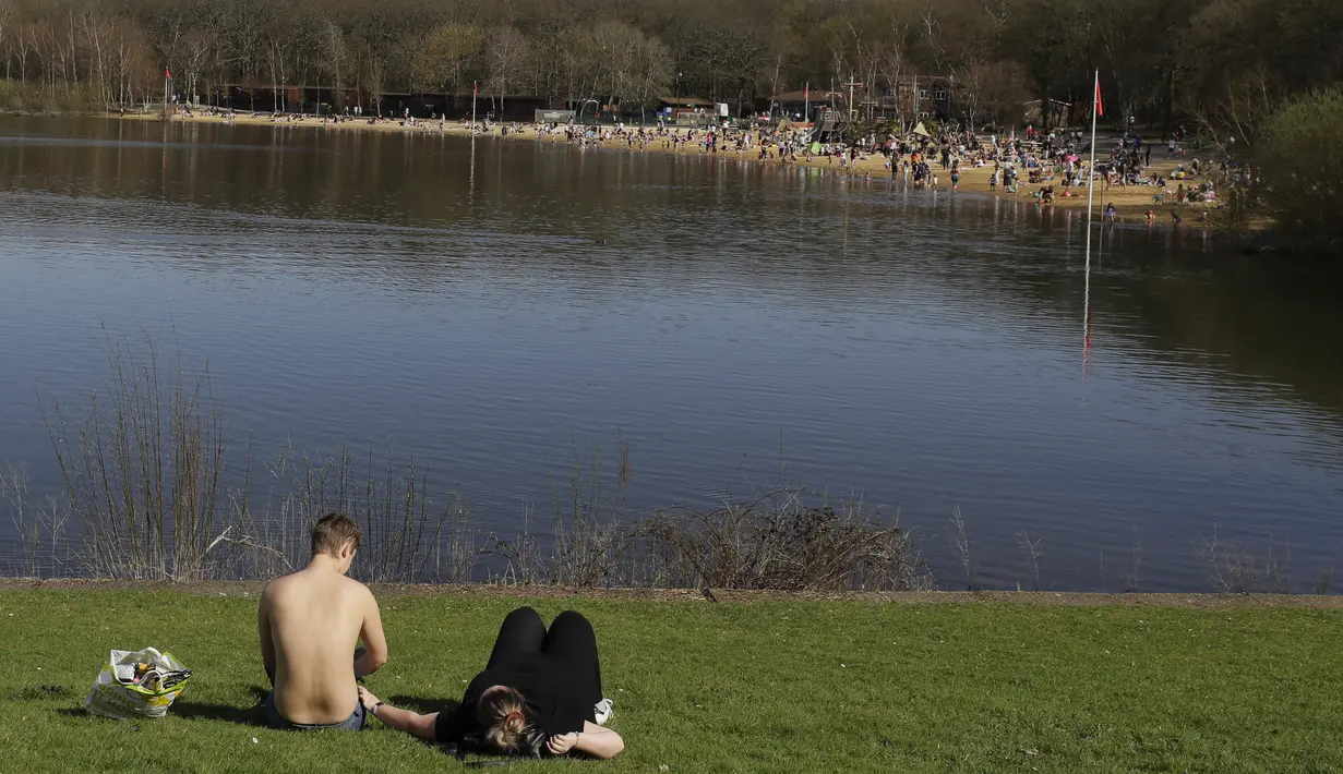 Orang-orang menikmati cuaca hangat di Ruislip Lido di London, Selasa (30/3/2021).  Suhu di beberapa bagian Inggris diperkirakan akan lebih hangat secara signifikan minggu ini karena keluarga dan teman berkumpul kembali da
