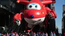 Peserta menerbangkan balon  karakter Jett pada animasi Super Wings dalam parade perayaan Hari Thanksgiving di kawasan Sixth Avenue, New York, Kamis (28/11/2019). Parade yang membelah jalanan kota New York ini selalu ditunggu setiap tahunnya. (AP Photo/Jeenah Moon)