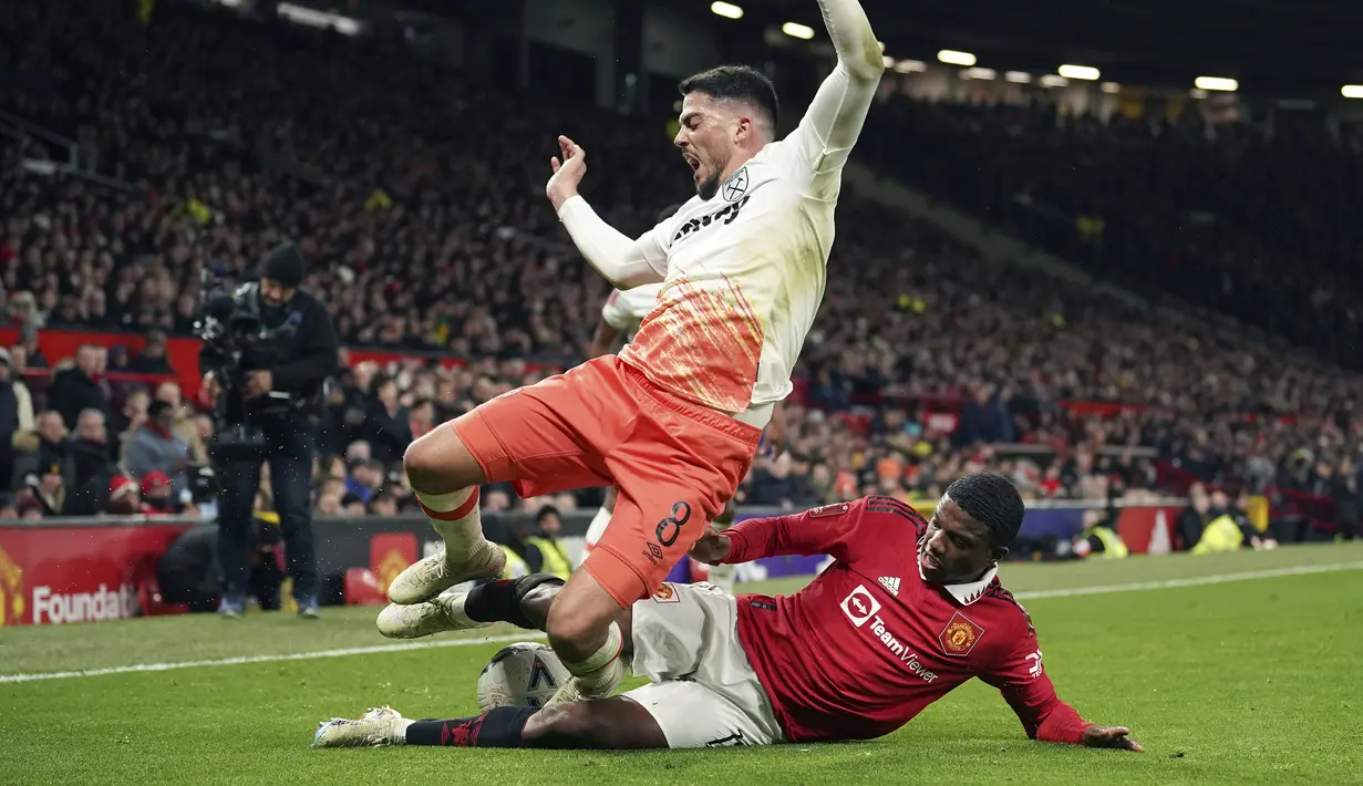 Pemain Manchester United, Tyrell Malacia (kanan) berebut bola dengan pemain West Ham, Pablo Fornals pada laga putaran kelima Piala FA 2022/2023 yang berlangsung di Stadion Old Trafford, Manchester, Kamis (02/03/2023) WIB. MU berhasil menang comeback 3-1. (AP Photo/Dave Thompson)
