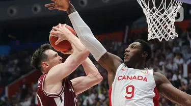 Pemain timnas basket Kanada, RJ-Barrett (kanan) berusaha menahan serangan pebasket Latvia, Rodions Kurucs pada laga terakhir penyisihan Grup H FIBA World Cup 2023 di Indonesia Arena, Gelora Bung Karno, Jakarta, Selasa (29/8/2023). (Liputan6.com/Helmi Fithriansyah)