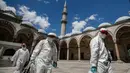 Pekerja mengenakan pakaian pelindung menyemprotkan disinfektan bagian Masjid Suleymaniye yang bersejarah pada hari ketiga Idul Fitri di Istanbul, Selasa (26/5/2020). Beberapa masjid didisinfektan sebelum dibuka kembali pada 29 Mei usai ditutup selama lebih dari enam minggu. (AP/Emrah Gurel)