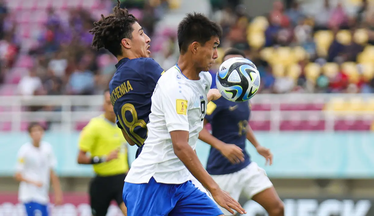 Pemain Timnas Uzbekistan U-17, Sherzodbek Abdulboriyev (kanan) berebut bola dengan pemain Timnas Prancis U-17, Mohamed-Amine Bouchenna pada laga perempat final Piala Dunia U-17 2023 di Stadion Manahan, Solo, Sabtu (25/11/2023). (Doc. LOC WCU17/NFL)