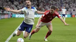 Gelandang Inggris Jordan Henderson berebut bola dengan bek Wales Ben Davies pada pertandingan terakhir Grup B di Ahmad bin Ali Stadium, Rabu (30/11/2022) dini hari WIB. Kemenangan itu membuat Inggris mantap di posisi puncak klasemen Grup B dengan tujuh poin. (AP Photo/Thanassis Stavrakis)