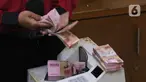 Petugas menghitung uang rupiah di penukaran uang di Jakarta, Senin (9/11/2020). Nilai tukar rupiah terhadap dolar AS bergerak menguat pada perdagangan di awal pekan ini Salah satu sentimen pendorong penguatan rupiah kali ini adalah kemenangan Joe Biden atas Donald Trump. (Liputan6.com/Angga Yuniar)