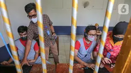 Anak binaan dibantu pegawai lapas anak tengah menyiapkan komunikasi virtual dengan keluarganya di Lembaga Pembinaan Khusus Anak (LPKA) Klas 1 Tangerang, Banten, Sabtu (30/5/2020). Kunjungan fisik diganti dengan komunikasi virtual selama pandemi Covid-19. (Liputan6.com/Fery Pradolo)