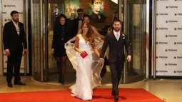 Bintang Barcelona, Lionel Messi, menggandeng sang istri, Antonella Roccuzzo, kelar dari ruang resepsi pernikahan untuk menemui wartawan Kompleks City Center, Santa Fe, Jumat (30/6/2017). (EPA/David Fernandez)