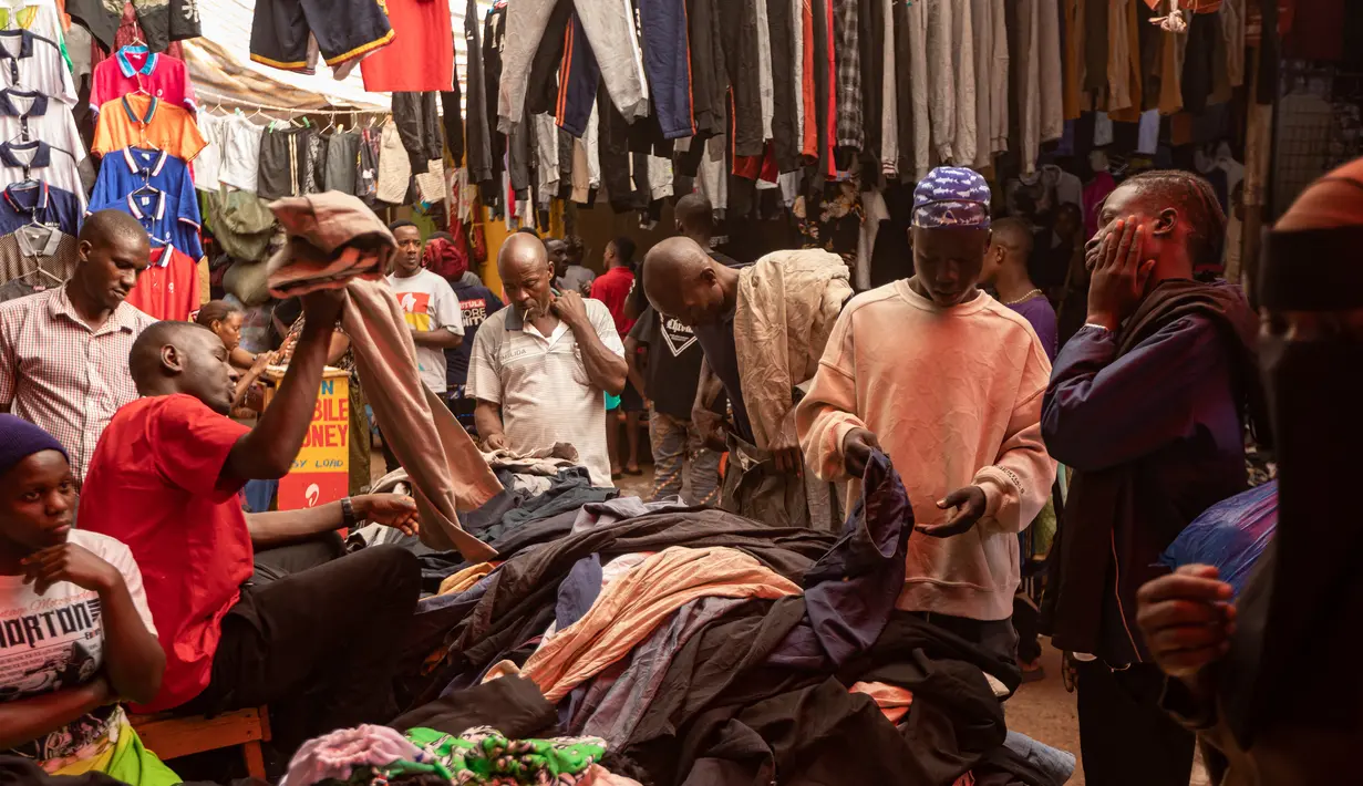 Pembeli memilih barang dari tumpukan pakaian bekas yang dijual di pasar di Kampala pada 7 Oktober 2023. (BADRU KATUMBA / AFP)